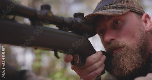 Close up of man hunting in woods with rifle