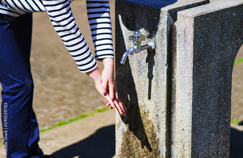 Japanese girl washing hands at park sunny day