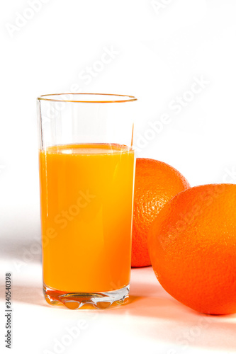 glass of fresh orange juice with fresh fruits on white background