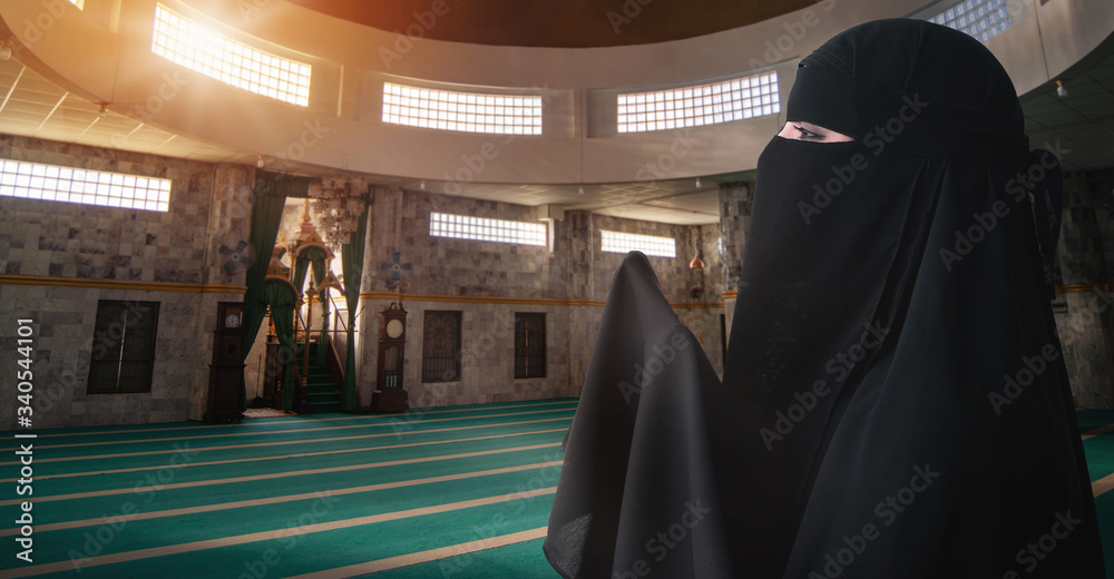 Muslim woman praying for god to bless her in mosque, woman with black niqab and hijab Muslim woman praying for god to bless her in mosque, woman with black niqab and hijab