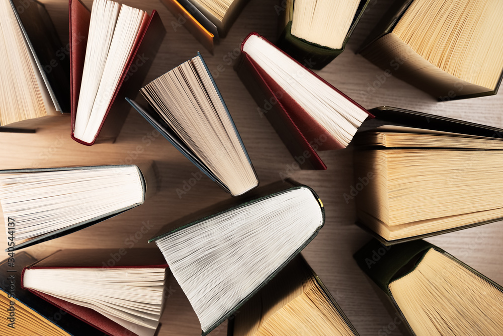 Fototapeta premium Books top view. They stand ajar on the table, the sheets spread out like a fan. Back to school. Education. Reading.