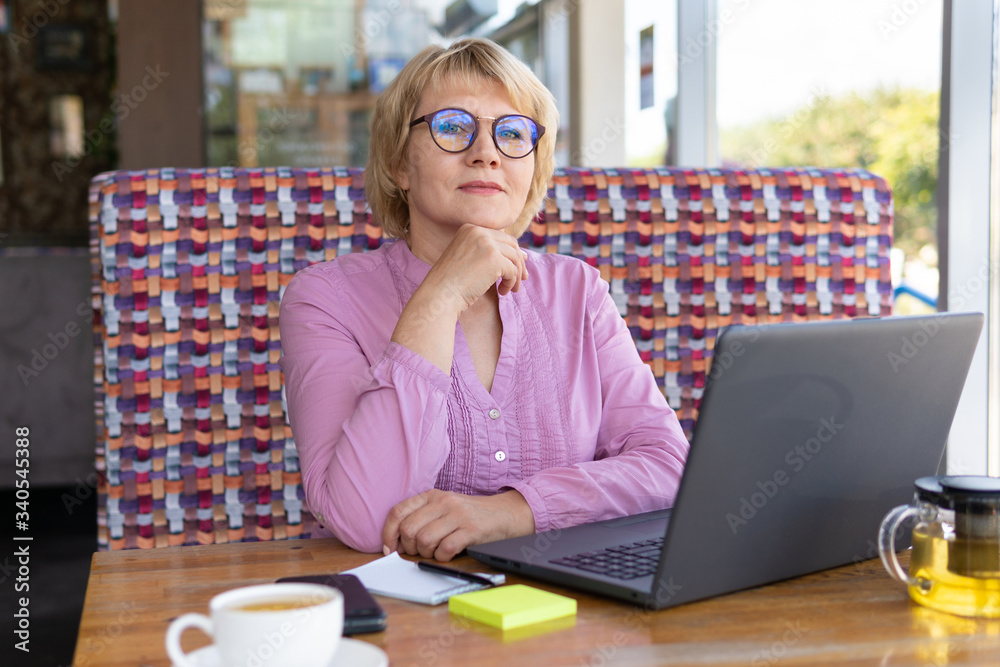A woman is working with a laptop at a table in the room A woman is working with a laptop at a table in the room