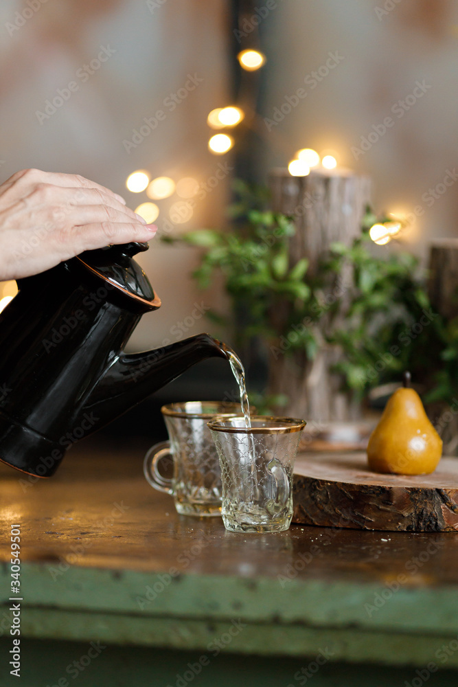 tea is poured into a turkish cup on the background of lights tea is poured into a turkish cup on the background of lights