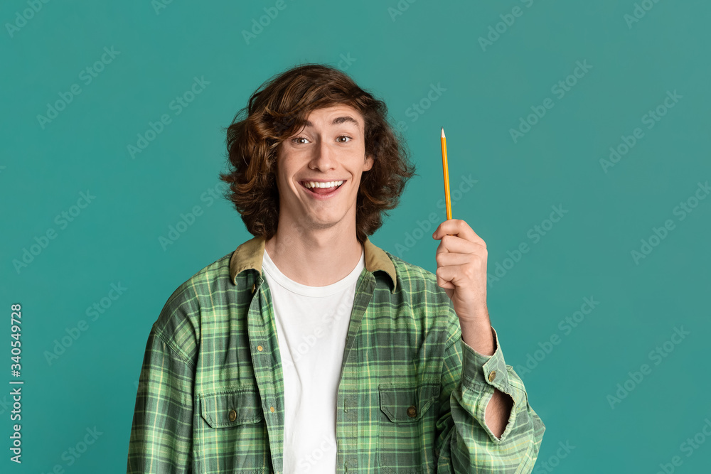 Having idea. Young guy pointing up pencil on color background Having idea. Young guy pointing up pencil on color background