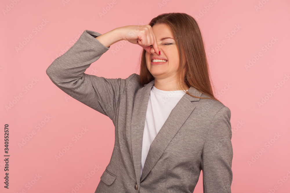 Bad smell! Portrait of young woman in business suit pinching nose and frowning in displeasure, expressing repulsion to stinky breath, awful odor, grimacing in disgust. indoor studio shot isolated Bad smell! Portrait of young woman in business suit pinching nose and frowning in displeasure, expressing repulsion to stinky breath, awful odor, grimacing in disgust. indoor studio shot isolated