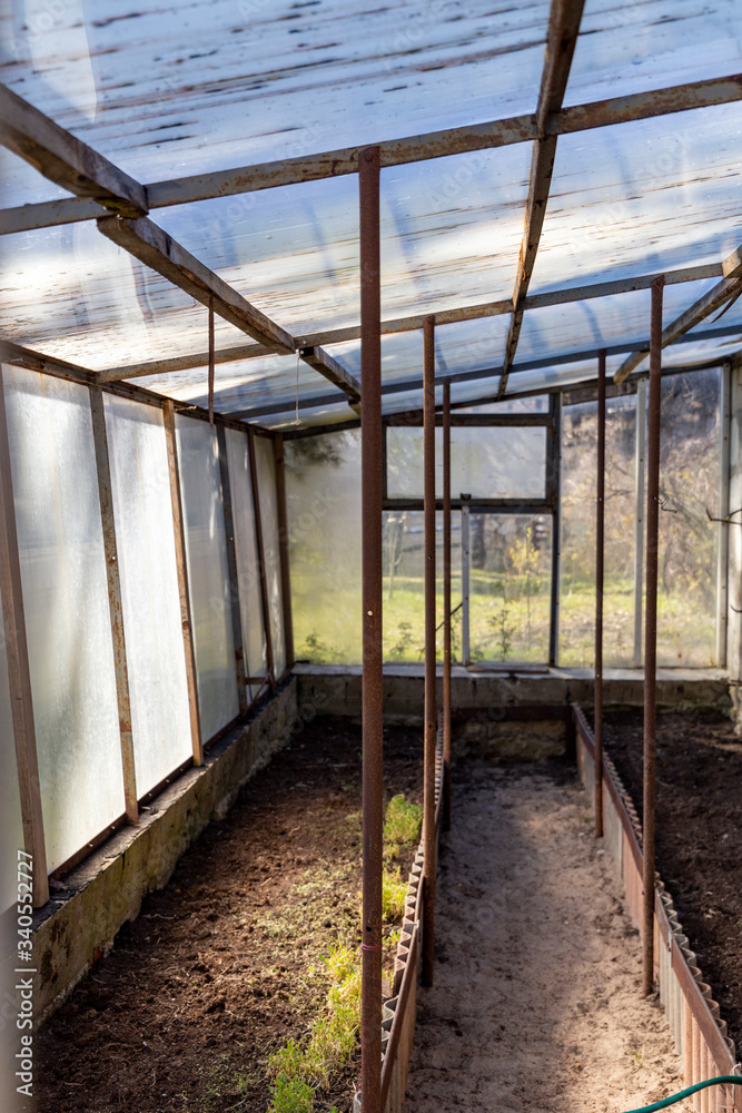 The small greenhouse is ready for work on a sunny spring day.