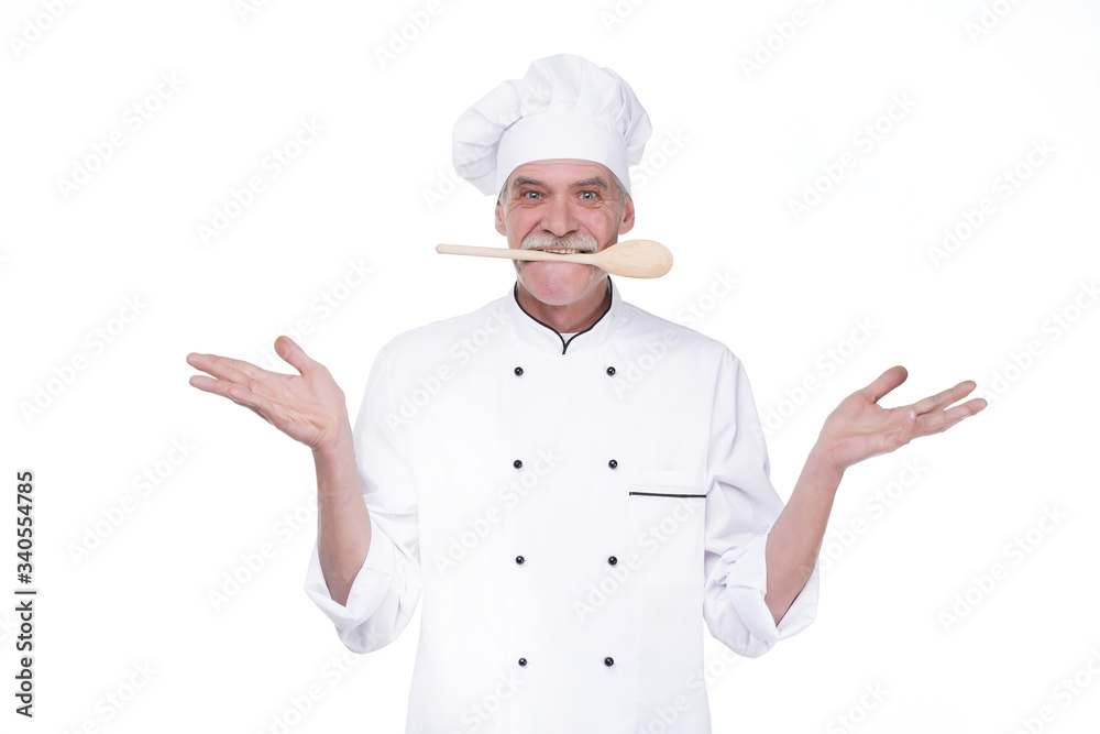 Male chef in uniform holding wooden spoon on mouse while staying on white background Male chef in uniform holding wooden spoon on mouse while staying on white background