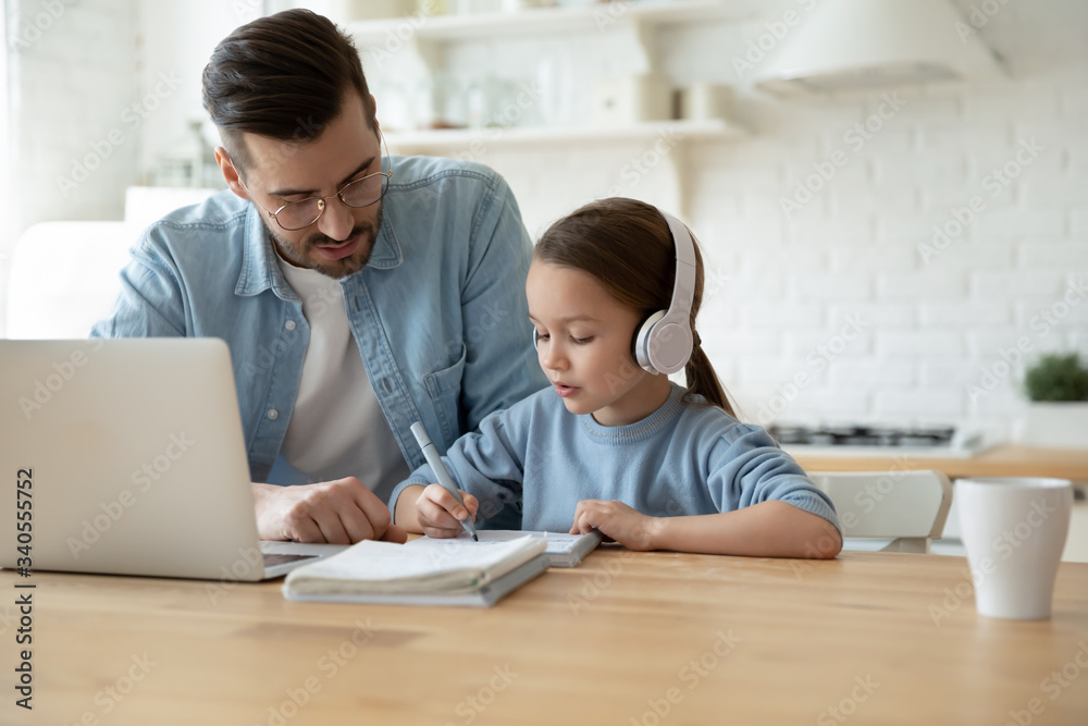 Caring young father help little preschooler daughter studying together watch online lesson on laptop, attentive dad and small girl child learn at home, have web class on computer on quarantine Caring young father help little preschooler daughter studying together watch online lesson on laptop, attentive dad and small girl child learn at home, have web class on computer on quarantine
