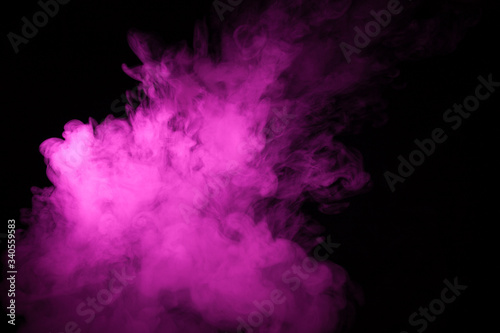 Colorful smoke close-up on a black background. Blurred pink cloud of smoke. © vfhnb12