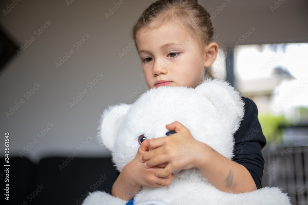 Child hugging teddy and thinking Child hugging teddy and thinking