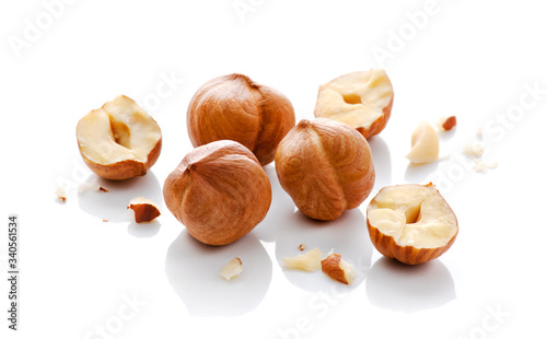 Full and halfs of hazelnuts on white background. Isolated photo