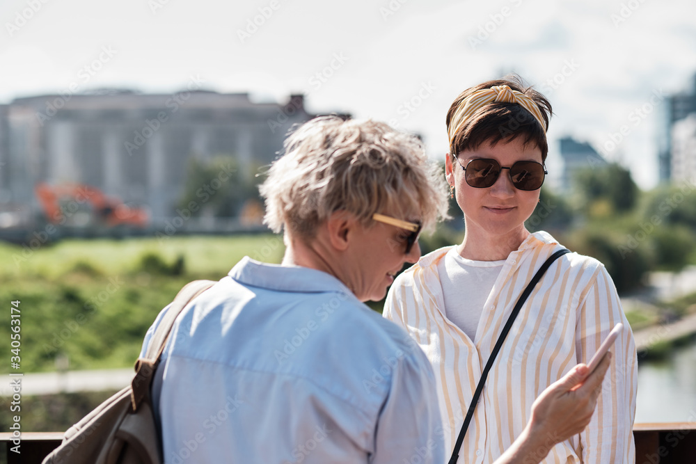 Two women checking their photo on smart phone Two women checking their photo on smart phone