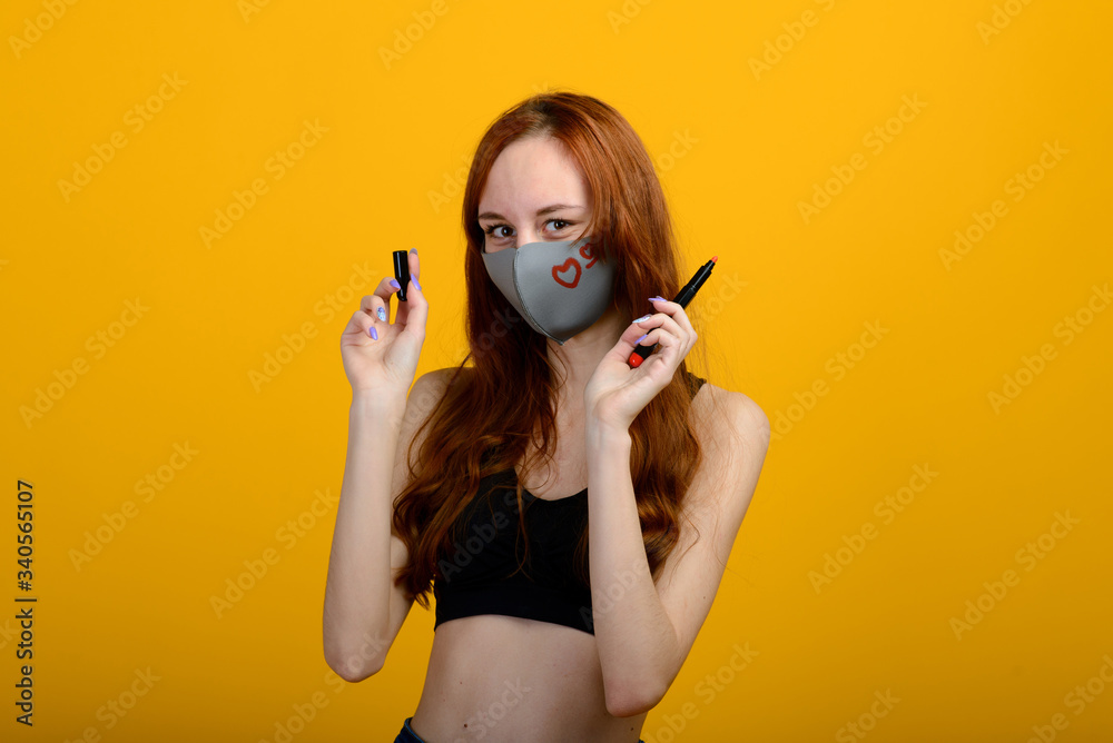 Portrait of a girl in a mask, which puts on a rubber glove. Yellow background. Portrait of a girl in a mask, which puts on a rubber glove. Yellow background.