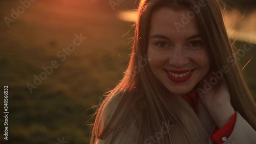 Sunshine young smiling woman with lomg hair look at camera on sunset photo