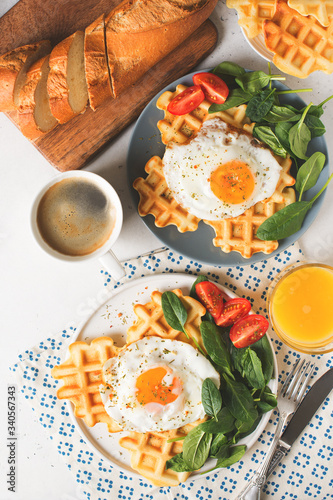 Fried egg, spinach, waffles and cup of coffee espresso, bread, baguette, muesli on white background