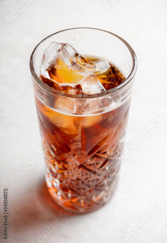 Cold cola beverage in glass with ice. Selective focus. Shallow depth of field.