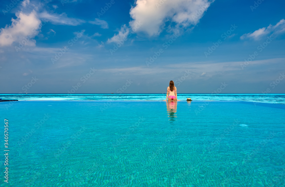 Woman in infinity swimming pool at Maldives