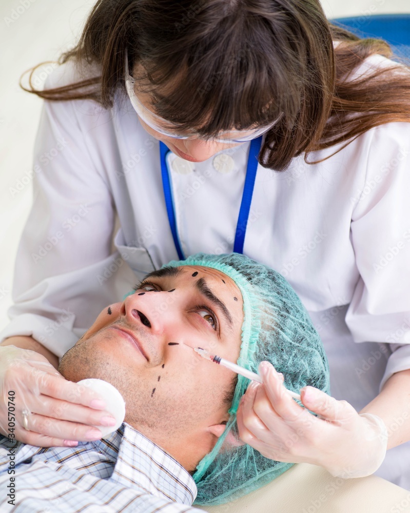 Plastic surgeon preparing for operation on man face Plastic surgeon preparing for operation on man face