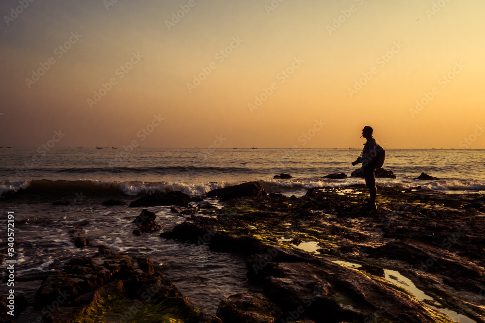 A man standing on a beach enjoying sunset - Rembang, Jawa Tengah, Indonesia A man standing on a beach enjoying sunset - Rembang, Jawa Tengah, Indonesia