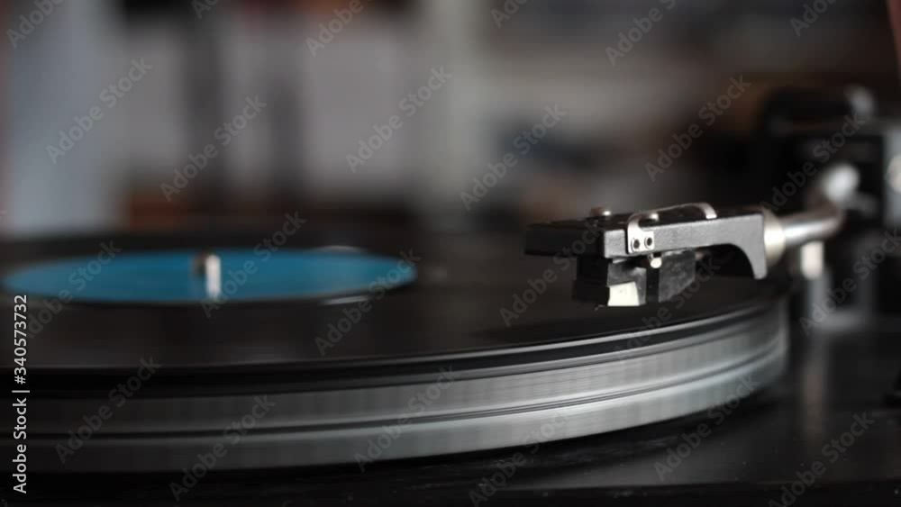 Close-up male hand starting retro record player, lay down the stylus, selective focus