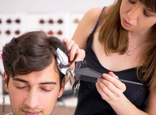 Young attracrive man visiting female barber