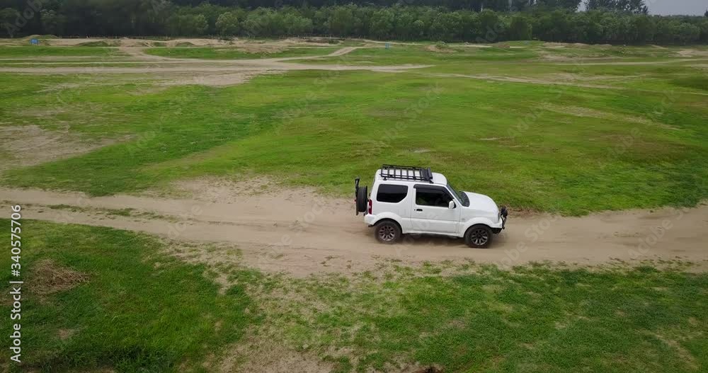 Drone shooting white off road vehicle running on the river bank Drone shooting white off road vehicle running on the river bank