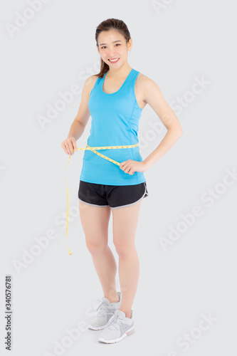 Beautiful slim young asian woman measuring tape thin waist wear uniform fitness isolated white background, asia girl loss weight for diet with exercise and workout wellbeing and healthy care body. © N_studio