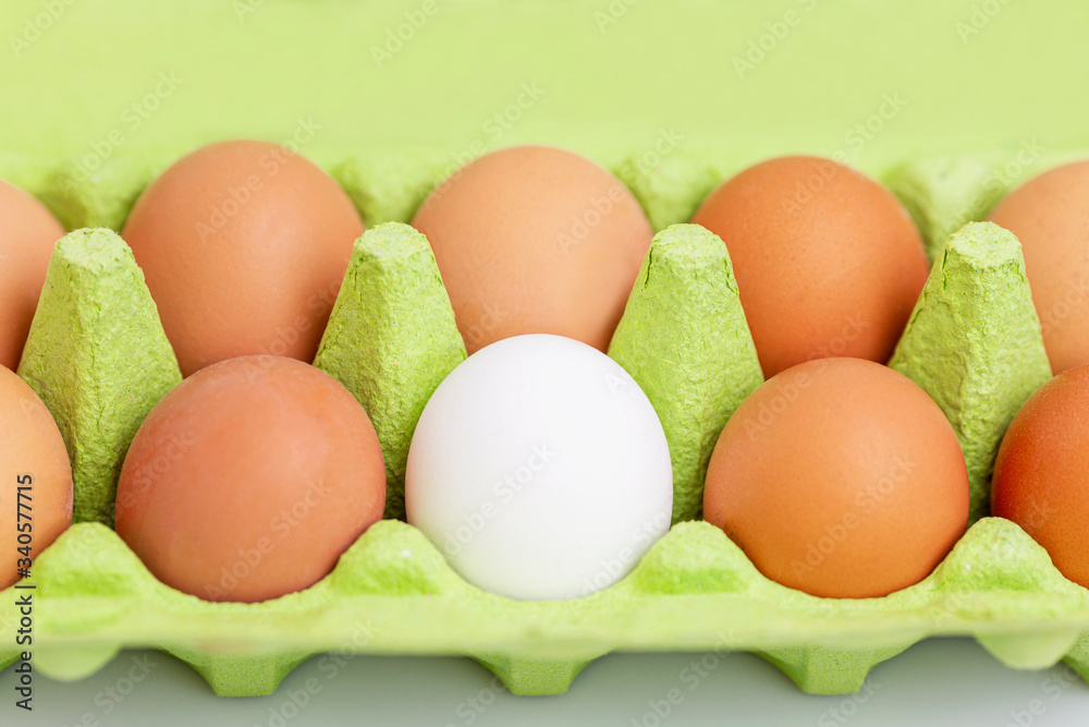 Cinnamon and one white chicken egg in an eco-green green paper container. Healthy diet food. Close-up. White background. Cinnamon and one white chicken egg in an eco-green green paper container. Healthy diet food. Close-up. White background.