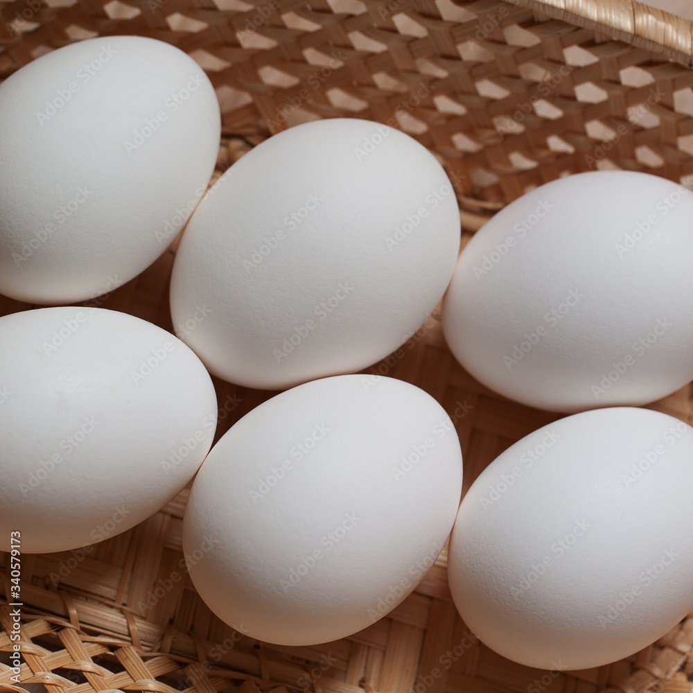 several fresh white chicken eggs on lie in a wicker basket several fresh white chicken eggs on lie in a wicker basket
