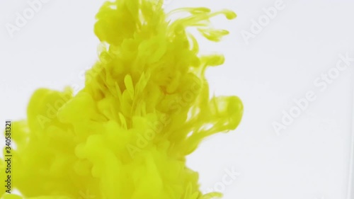 Dark Yellow color paint ink drops in water, slow motion full hd video, white background. smoke explosion abstract visual. Inky cloud swirling flowing underwater.