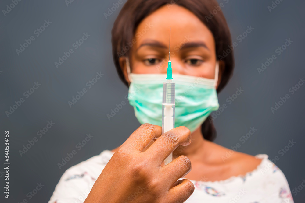 coronavirus epidemic from china. selective focus. woman doctor use syringe. nurse make injection in respirator mask. health worker dials vaccine in syringe. Physician or giving vaccine against virus