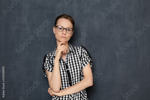 Portrait of serious focused young woman with glasses
