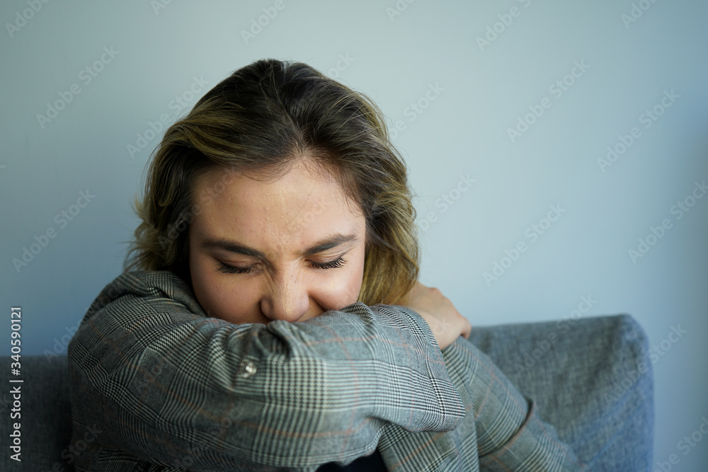 Cough in tissue covering nose and mouth when coughing. European woman sick with flu at home. Cough in tissue covering nose and mouth when coughing. European woman sick with flu at home.