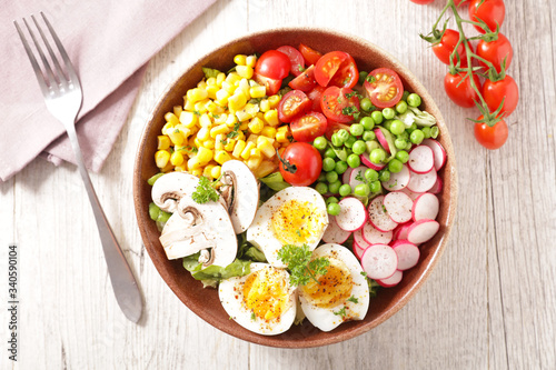 vegetable salad bowl with tomato, egg, corn, radish and pea