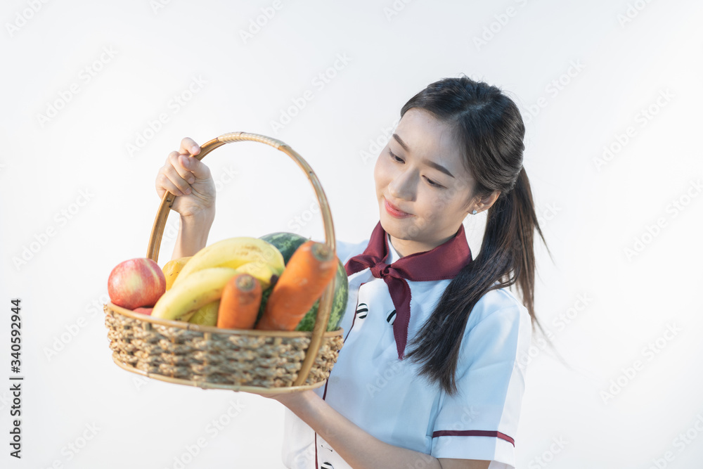A cute girl makes vegetable juice, with carrot apple orange cranberry beetroot and mango in chef suit. A cute girl makes vegetable juice, with carrot apple orange cranberry beetroot and mango in chef suit.
