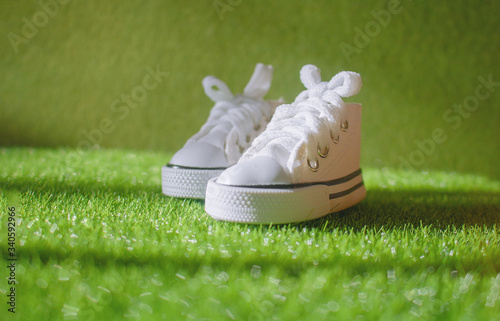 Unisex White sneakers on grass in the park. side view and copy space. Health sport and fashion concept. no people no body