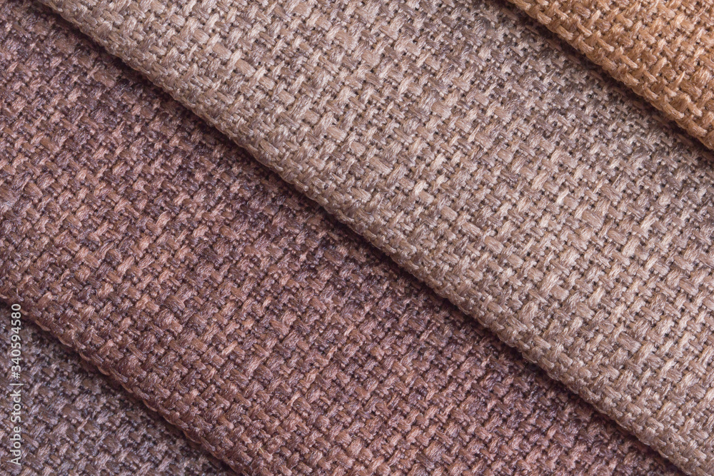 A set of colored samples of upholstery fabric for furniture in stock. Background from rolls of multi-colored fabric, empty template. Fabric Gun for upholstery in brown shades. A set of colored samples of upholstery fabric for furniture in stock. Background from rolls of multi-colored fabric, empty template. Fabric Gun for upholstery in brown shades.