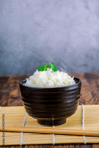 Cooked plain white basmati rice in terracotta bowl over plain background