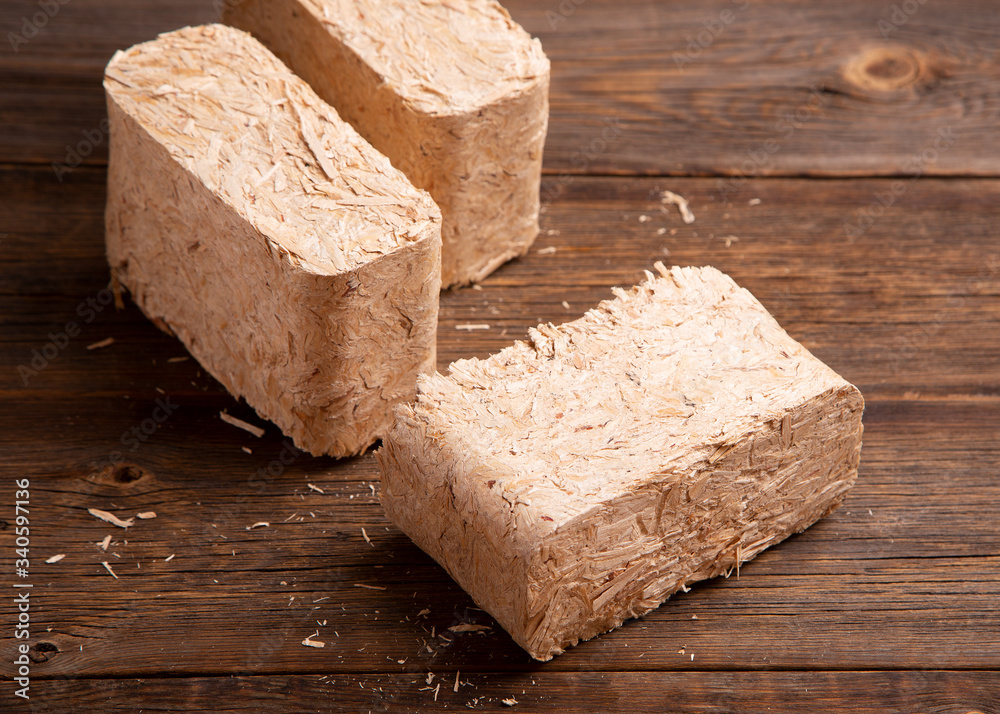 Set of fuel briquettes on a wooden background. Pressed sawdust fuel briquettes. Briquettes for the oven close-up.
