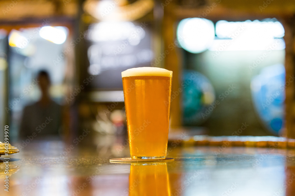 a large and fresh beer with foam on a bar a large and fresh beer with foam on a bar