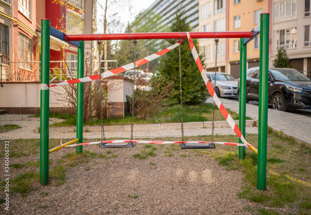 Playground wrapped in striped red white tape, stay home. Quarantine area for sports, prevention of infection with the covid-19 coronavirus influenza virus