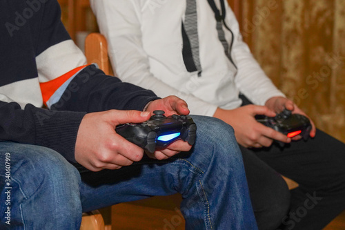 boys are playing Sony PlayStation. Boy playing with a joystick. A boy enjoy playing game on Sony PlayStation at home. 