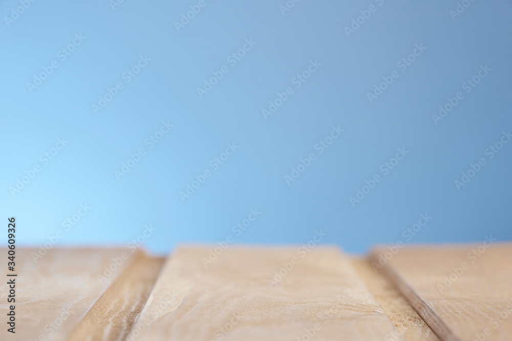 Wooden surface on a blue lighted background in a blur. Photo from copy space.