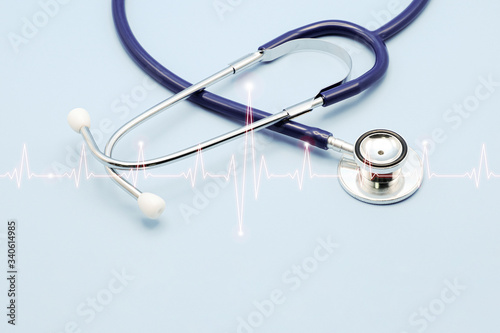 Double exposure of medical stethoscope and cardiogram isolated on light blue. Cardiac therapeutics assistance  pulse beat measure  arrhythmia pacemaker medical healthcare concept with copy space.