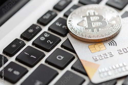 Credit card and bitcoin on the computer keyboard