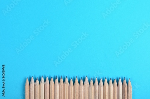 Lot of wooden pencils on blue paper background