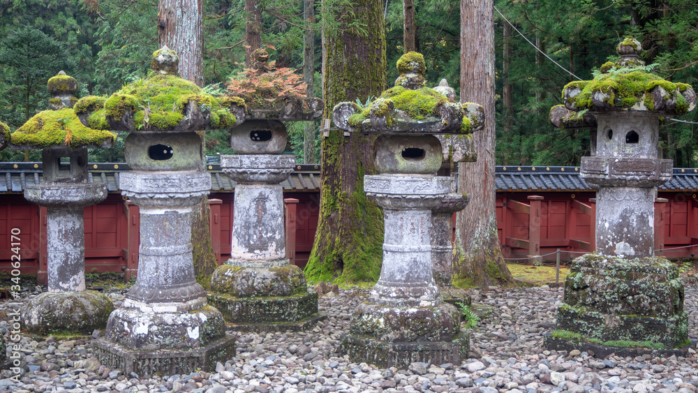 Stone lanterns with refreshing green moss on gravel yard in japanese temple garden for background, copy space