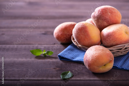 bowl with some peaches  on wooden table