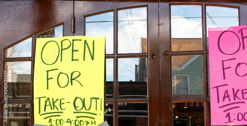 Open for Take-Out only posters on windows of restaurant photo