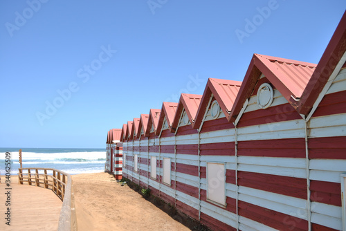 Casetas rojas y blancas de playa sobre la arena cerca del mar